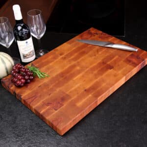 Stirnholz Schneidebrett Aus Apfelbaum In Moderner Küche, Hochwertige Messer Und Weintrauben, Und Weindekoration Im Hintergrund