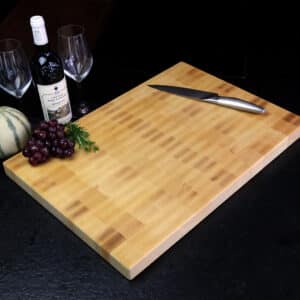 Stirnholz Schneidebrett Aus Birke In Moderner Küche, Hochwertige Messer Und Weintrauben, Und Weindekoration Im Hintergrund