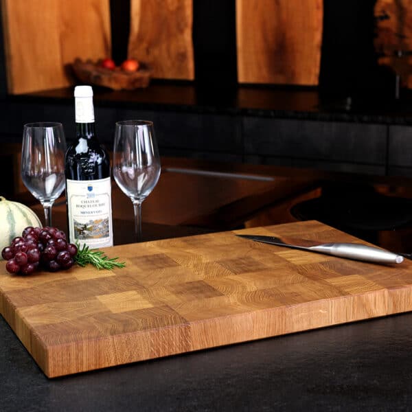 Stirnholz Schneidebrett Aus Eiche In Moderner Küche, Hochwertige Messer Und Weintrauben, Und Weindekoration Im Hintergrund