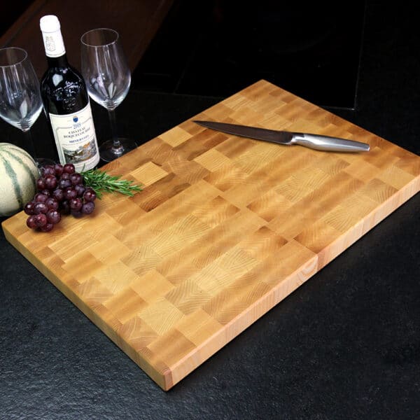 Stirnholz Schneidebrett Aus Esche In Moderner Küche, Hochwertige Messer Und Weintrauben, Und Weindekoration Im Hintergrund