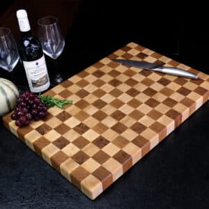 Stirnholz-Schneidebrett-Schachbrett In Moderner Küche, Hochwertige Messer Und Weintrauben, Und Weindekoration Im Hintergrund